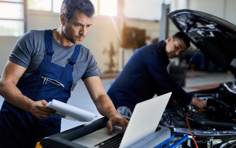 mid-adult-mechanic-using-laptop-car-diagnostic-while-working-with-colleague-auto-repair-shop (1)